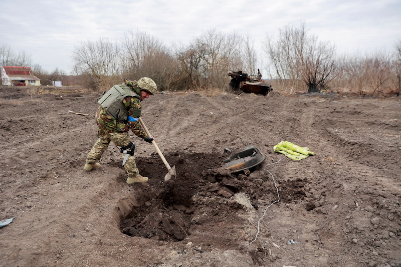A Ukrainian serviceman buries the remains of what he says is a dead body of a Russian soldier in the village of Lukianivka amid Russia's invasion, in Kyiv region, Ukraine March 28, 2022. u00e2u20acu201d Reuters pic