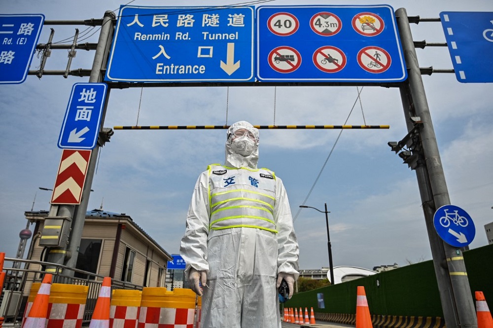 A transit officer, wearing a protective gear, controls access to a tunnel in the direction of Pudong district in lockdown as a measure against the Covid-19 coronavirus, in Shanghai March 28, 2022. u00e2u20acu201d AFP pic