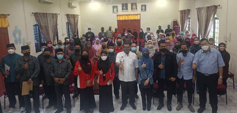 Hasbi (front fifth right) and others in a photocall with participants of the Community Financial Literacy programme. u00e2u20acu201d Borneo Post pic