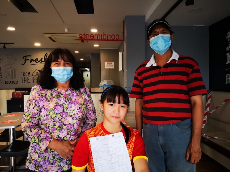Regina with her adoptive parents Ginom (left) and Labo. u00e2u20acu201d Borneo Post pic