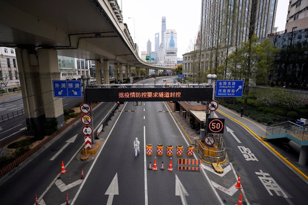 A worker in a protective suit walks at an entrance to a tunnel leading to the Pudong area, after restrictions on highway traffic amid the lockdown to contain the spread of Covid-19 in Shanghai March 28, 2022. u00e2u20acu201d Reuters pic