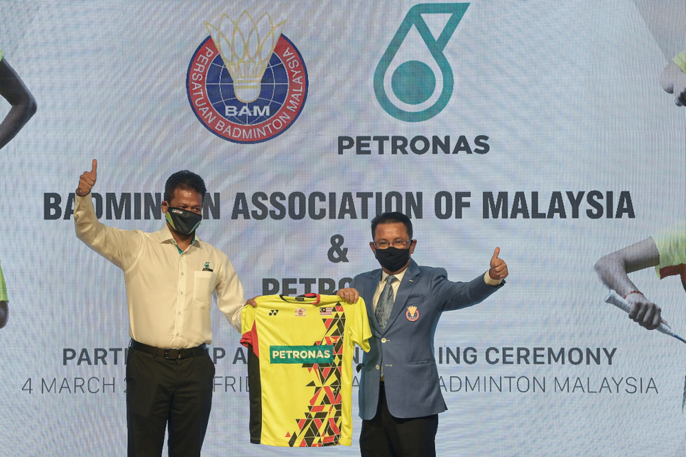 BAM president Tan Sri Mohamad Norza Zakaria (right) and Petronas Dagangan Berhad MD and CEO Azrul Osman Rani with the new official team jersey for Malaysiau00e2u20acu2122s badminton players at Akademi Badminton Malaysia, Bukit Kiara, March 4, 2022. u00e2u20acu2022 Bernama pic 