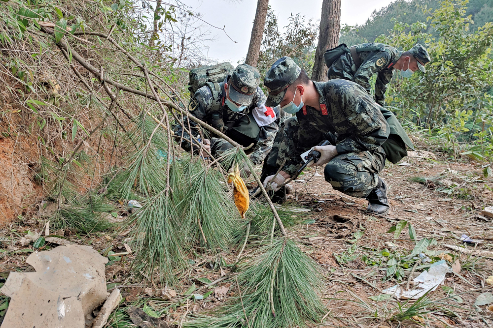 This photo taken March 21, 2022 shows paramilitary police officers conducting a search at the site of the China Eastern Airlines plane crash in Tengxian county, Wuzhou city, in Chinau00e2u20acu2122s southern Guangxi region. u00e2u20acu201d CNS pic via AFPnn