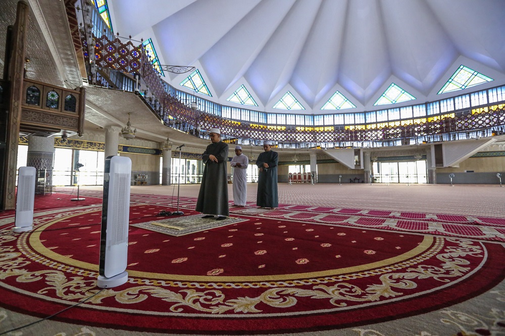 As a Muslim, this was the first time I had seen an empty mosque during Friday prayers; there were only these three mosque officials performing the prayers. ― Picture by Yusof Mat Isa
