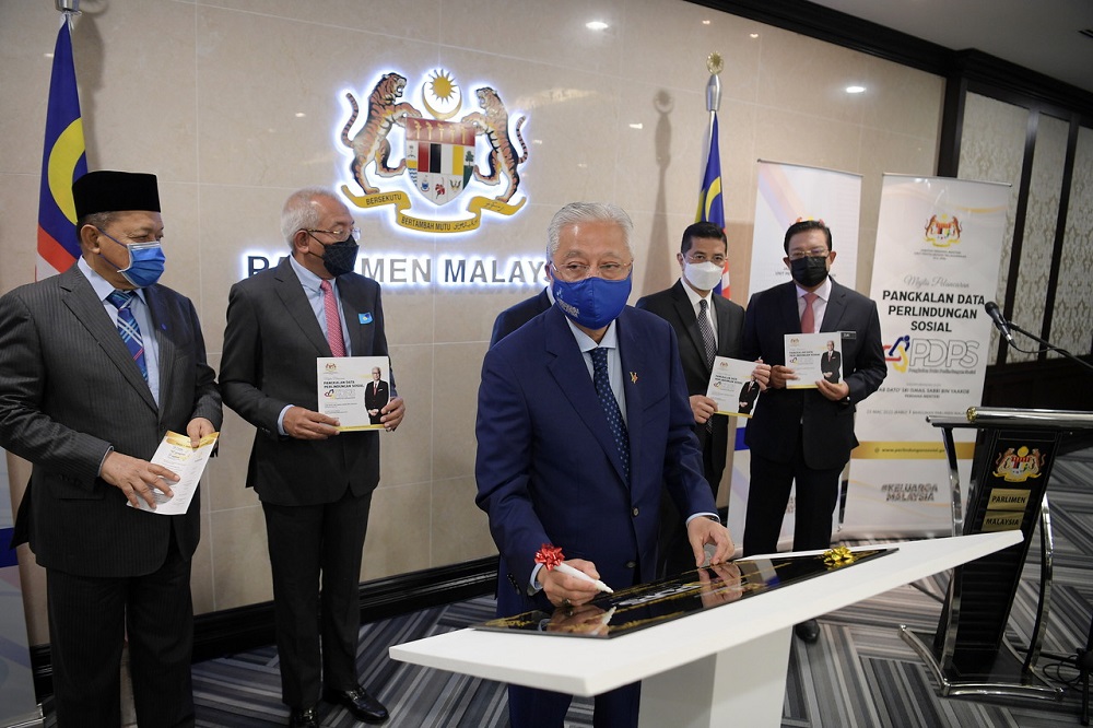 Prime Minister Datuk Seri Ismail Sabri Yaakob (centre) signs a plaque during the launch of the Social Protection Database at the Parliament building in Kuala Lumpur March 23, 2022. u00e2u20acu201d Bernama pic