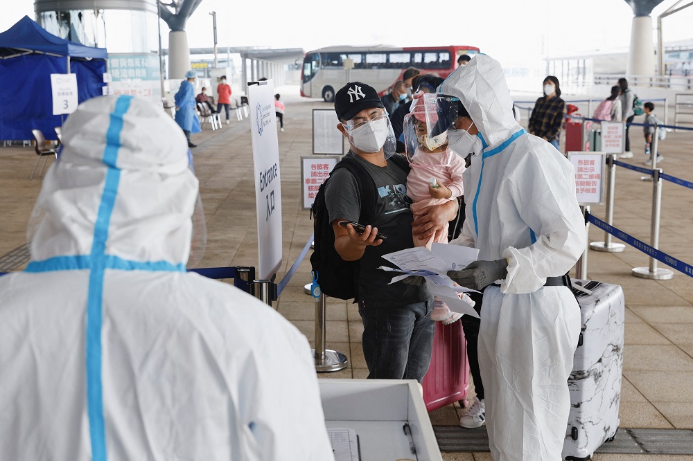 A health worker wearing personal protective equipment assists people at the Hong Kong-Zhuhai-Macao Bridge Hong Kong Port in Hong Kong March 22, 2022. u00e2u20acu2022 Reuters pic