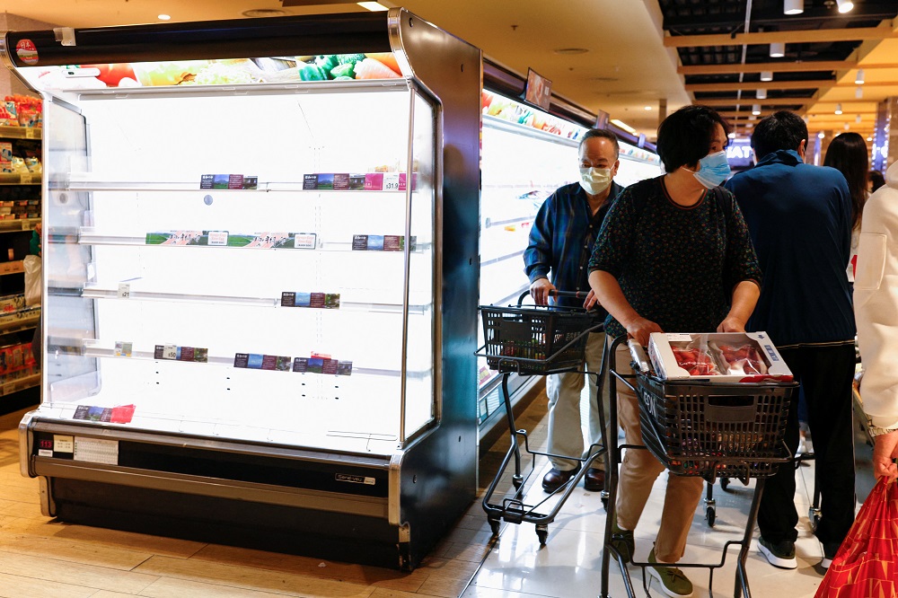 Customers wearing face masks shop in front of partially empty shelves at a supermarket in Hong Kong March 2, 2022. u00e2u20acu2022 Reuters pic