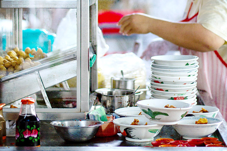 Preparing bowls of prawn cracker noodles.