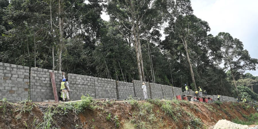 Workers construct a protective fence for the Banco National Park in Abidjan on March 10, 2022.u00e2u20acu201d ETX Studio picnn