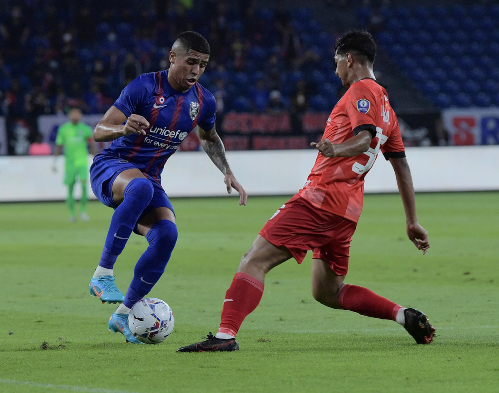 JDTu00e2u20acu2122s Bergson Da Silva tries to get past Sarawak United FCu00e2u20acu2122s Ahmad Tasnim Fitri Mohd Nasir at the Sultan Ibrahim Stadium in Iskandar Puteri, March 9, 2022. u00e2u20acu201d Bernama pic 