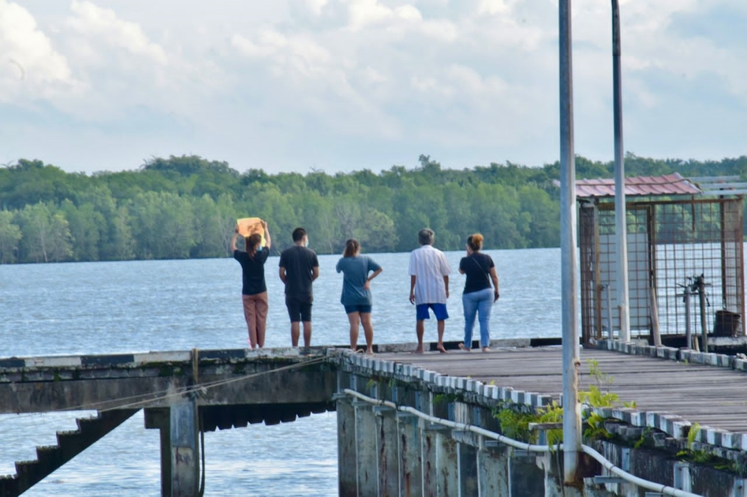 Eric Changu00e2u20acu2122s parents (left, 2nd left) and relatives perform prayers for the missing four-year-old at Muara Tebas Wharf. u00e2u20acu201d Roystein Emmor/Borneo Post pic
