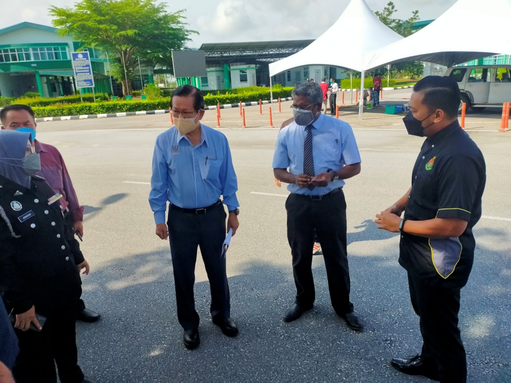 Transport Minister Datuk Sri Lee Kim Shin (second left) talks to Immigration officers and MDDMC members during the visit to Sungai Tujuh CIQS. On his left is Dr P Raviwharmman. u00e2u20acu201d Borneo Post Online pic 