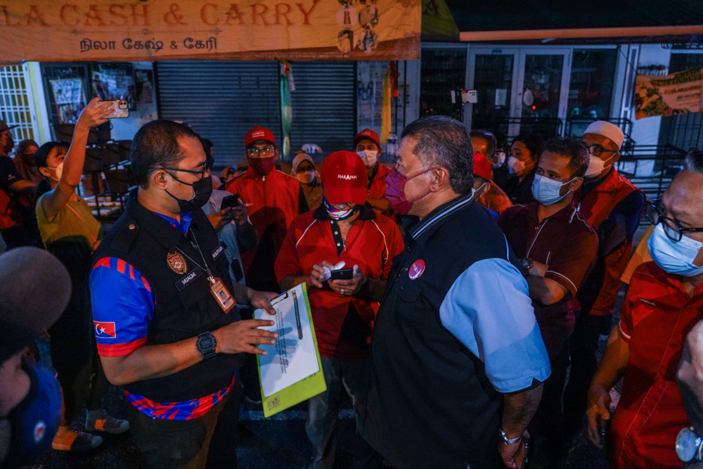 Enforcement personnel from the Health Ministry issue a compound to the organiser at Pakatan Harapan’s Ceramah Mega, main operations room for DUN N49 Kota Iskandar, Skudai, March 1, 2022. ― Picture by Hari Anggara 