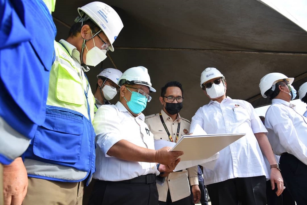 Abang Johari (second right) looks at a document during his visit to the methanol project site. u00e2u20acu201d Picture courtesy of UKAS via Borneo Post Online