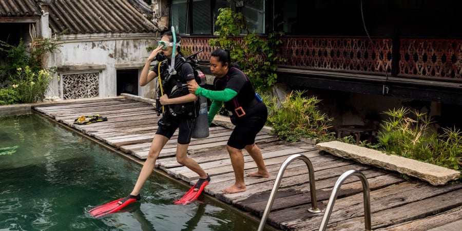 Pijitra Siriaiyara jumps into the swimming pool during a scuba diving lesson at the So Heng Tai mansion in the Talad Noi neighbourhood of Bangkok. u00e2u20acu2022 ETX-Studio picnn