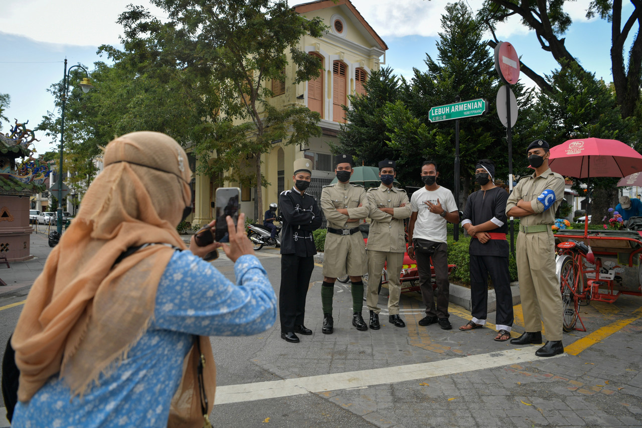 People who visited the tourist hotspots at Lebuh Armenian in George Town March 26, 2022, were surprised by the presence of policemen wearing old uniforms in conjunction with the 215th Police Day celebration. u00e2u20acu201d Bernama pic