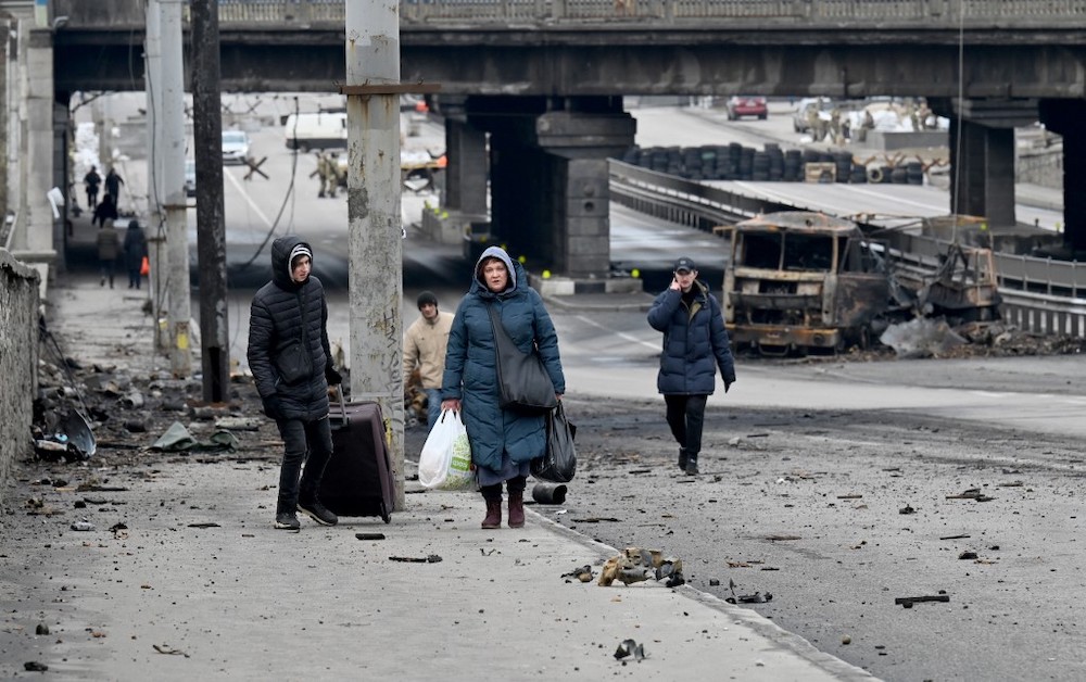 People carry their belongings as they walk past debris of last weeks combat in the Ukrainian capital of Kyiv on March 4, 2022. u00e2u20acu2022 AFP picnn