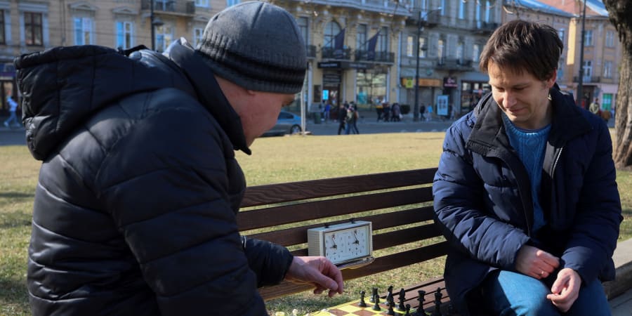 Andrei Volokitin, the 35 year-old chess grandmaster and the reigning champion of Ukraine, plays chess with amateur players at a bench on the central promenade in the western Ukrainian city of Lviv.u00e2u20acu201d ETX Studio picnn
