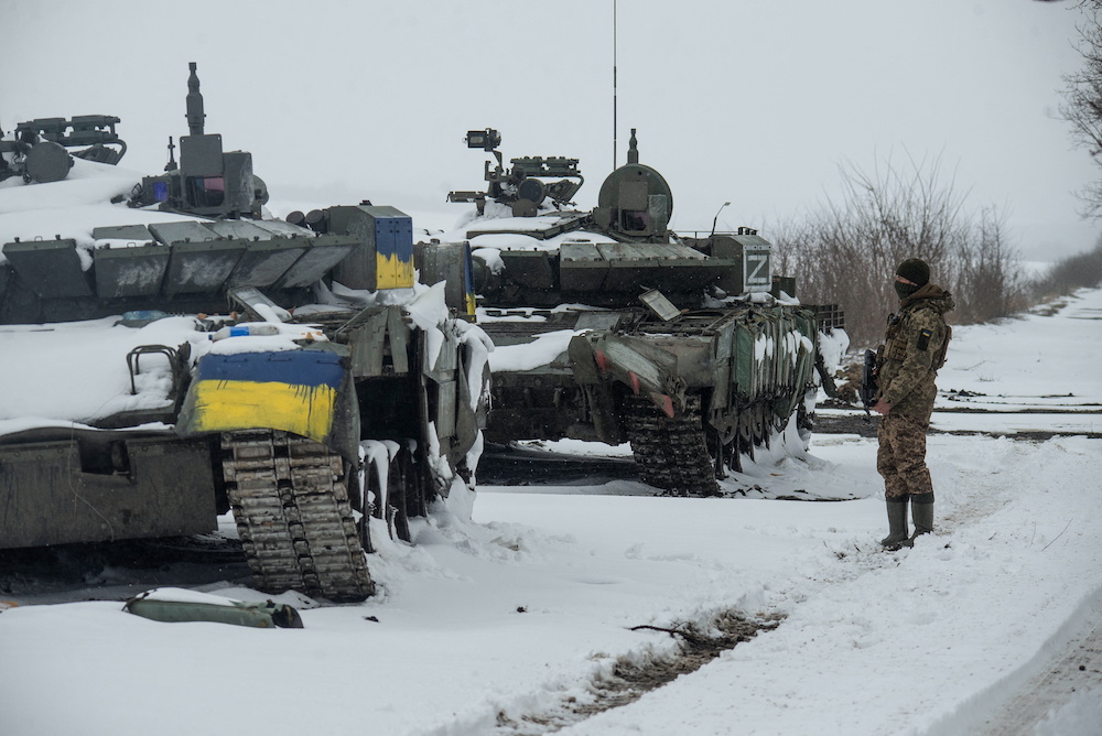 A Ukrainian serviceman stands near captured Russian tanks, one painted in the colour of the Ukrainian national flag and the other marked with the letter u00e2u20acu02dcZu00e2u20acu2122, amid the Russian invasion of Ukraine, in the north of the Kharkiv region, Ukraine March 4, 20