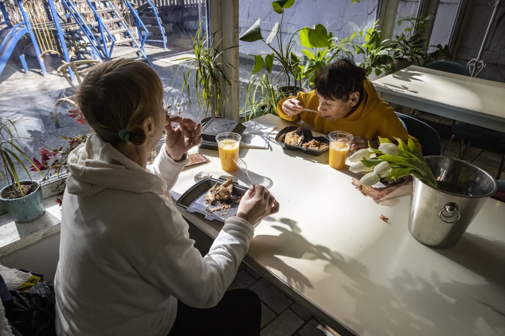 Residents eat a meal from the luxury Chernomorka restaurant which is distributing free food to locals in need in Kyiv on March 19, 2022. u00e2u20acu201d AFP pic