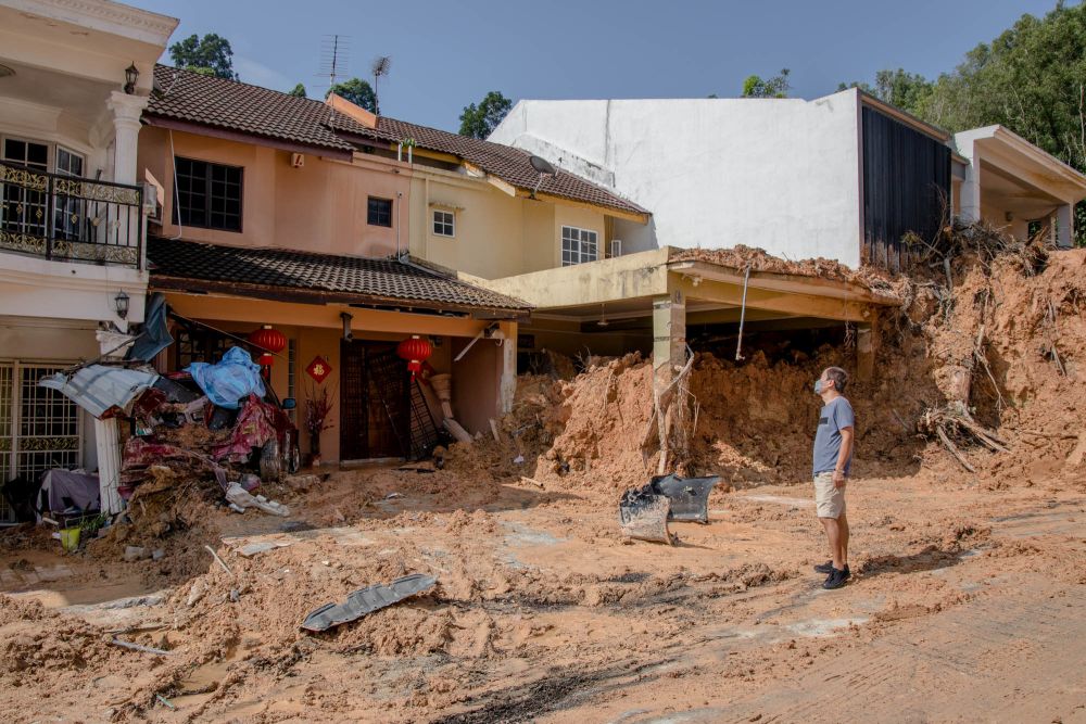 A man surveys the site of a landslide at Taman Bukit Permai 2 in Ampang March 22, 2022. u00e2u20acu201d Picture by Firdaus Latif