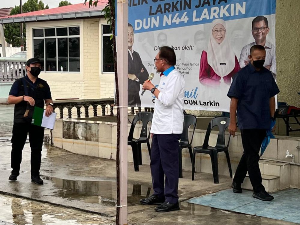 PKR president Datuk Seri Anwar Ibrahim (centre) cautioning the Johor Baru Heath Departmentu00e2u20acu2122s inspectorate officer (far left) to keep his distance, during his speech at the Larkin Jaya operations centre in Johor Baru, March 5, 2022. u00e2u20acu201d Picture by Ben Ta