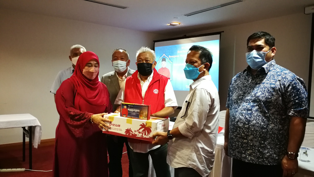 Bung Moktar handing over the dates to Mosliati Muslimin from Umno Kota Kinabalu. u00e2u20acu201d Borneo Post Online pic 