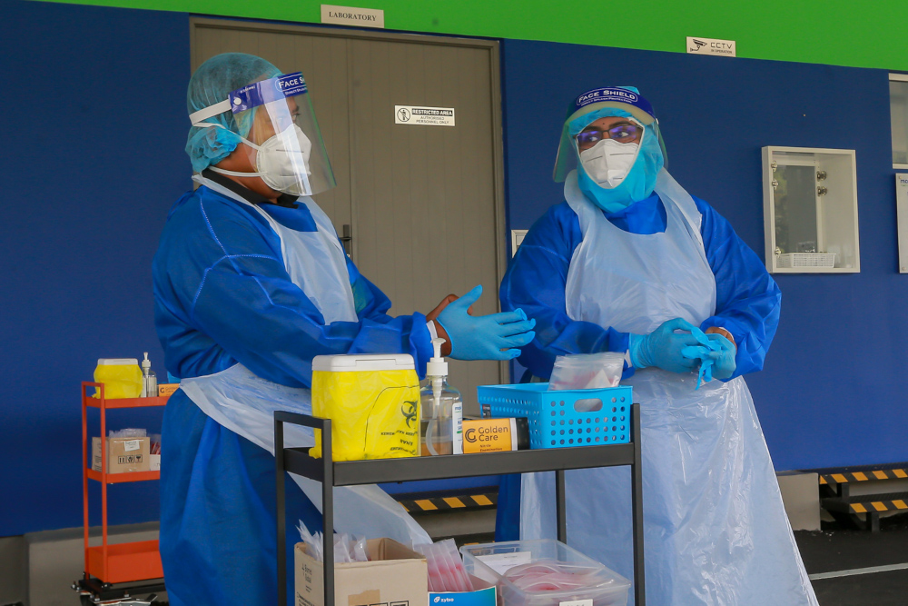 Health professionals in protective gear at the Mex Drive-Thru Screening and Testing Centre in Seri Kembangan, March 28, 2022. u00e2u20acu2022 Picture by Devan Manuel