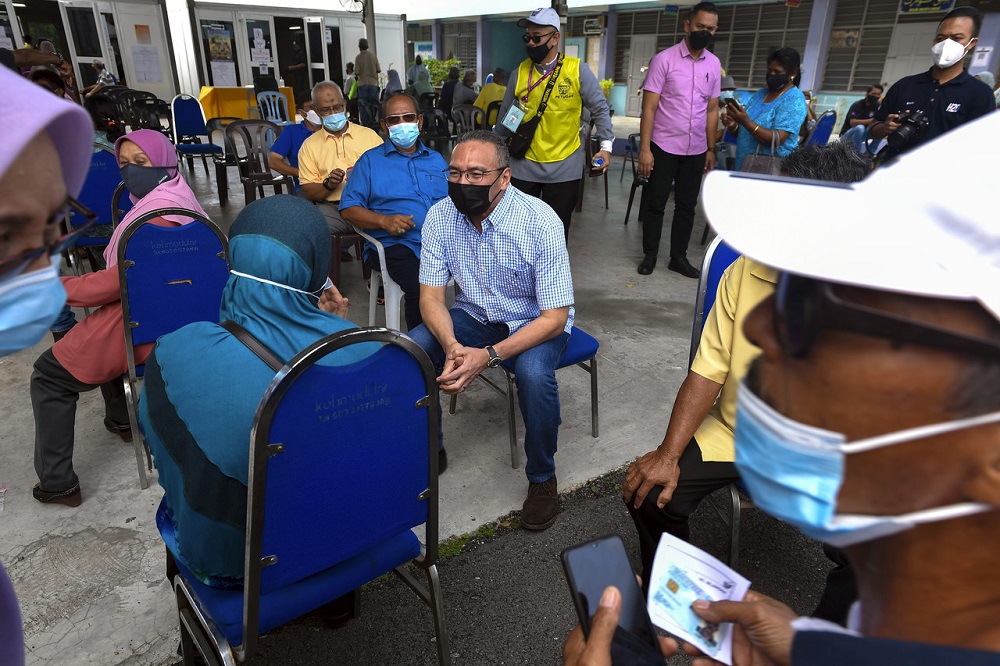 Senior Defence Minister Datuk Seri Hishammuddin Hussein chats to voters at the Sekolah Agama Taman Sri Lambak polling centre in Kluang March 12, 2022. u00e2u20acu2022 Bernama pic