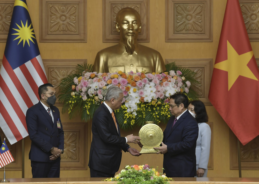 Prime Minister Datuk Seri Ismail Sabri Yaakob receives a souvenir from his Vietnamese counterpart Pham Minh Chinh at Government Office in Hanoi, March 21, 2022. u00e2u20acu201d Bernama pic 