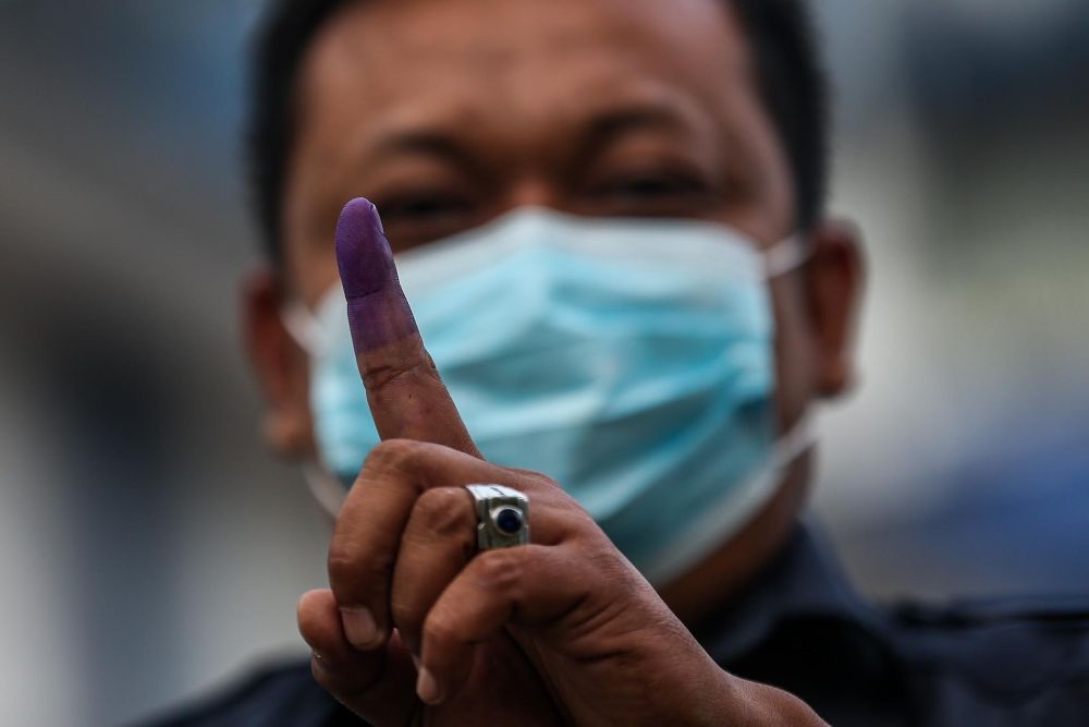 nA police officer shows his ink-stained finger after casting his ballot during early voting for the Johor state election in Johor Baru March 8, 2022. u00e2u20acu201d Picture by Hari Anggaran