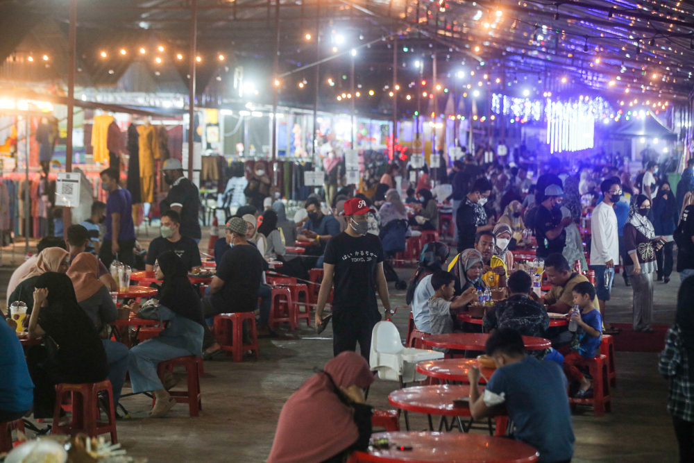 Patrons eat at the Ipoh night market March 9, 2022, as Malaysia gears up to transition to the endemic phase on April 1. u00e2u20acu201d Picture by Farhan Najib