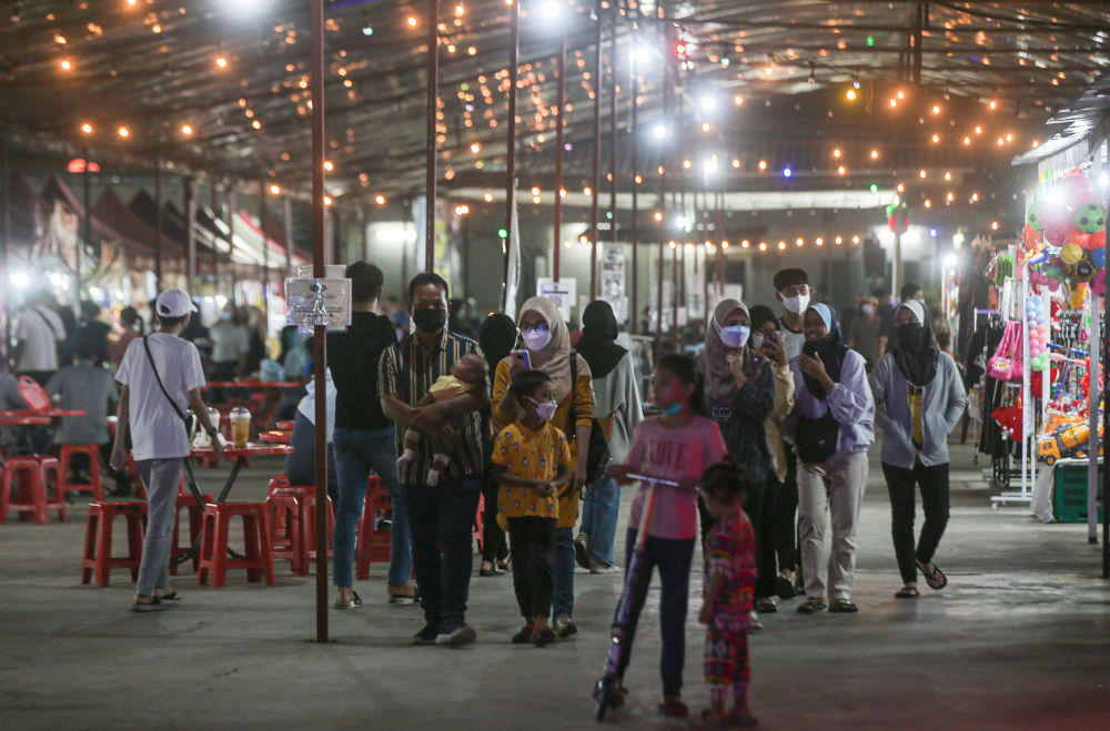 Patrons eat at the Ipoh night market March 9, 2022, as Malaysia gears up to transition to the endemic phase on April 1. u00e2u20acu201d Picture by Farhan Najib