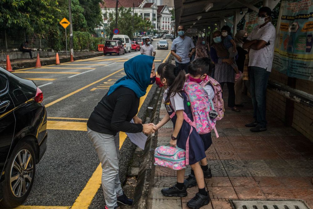 A mother kissing her daughter after dropping her off at school. — Picture by Firdaus Latif 