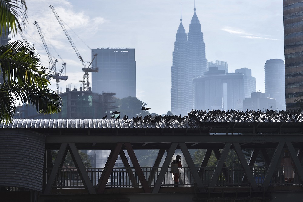 A worker was seen carrying out a disinfection exercise with the KLCC in the background. u00e2u20acu2022 Picture by Miera Zulyana