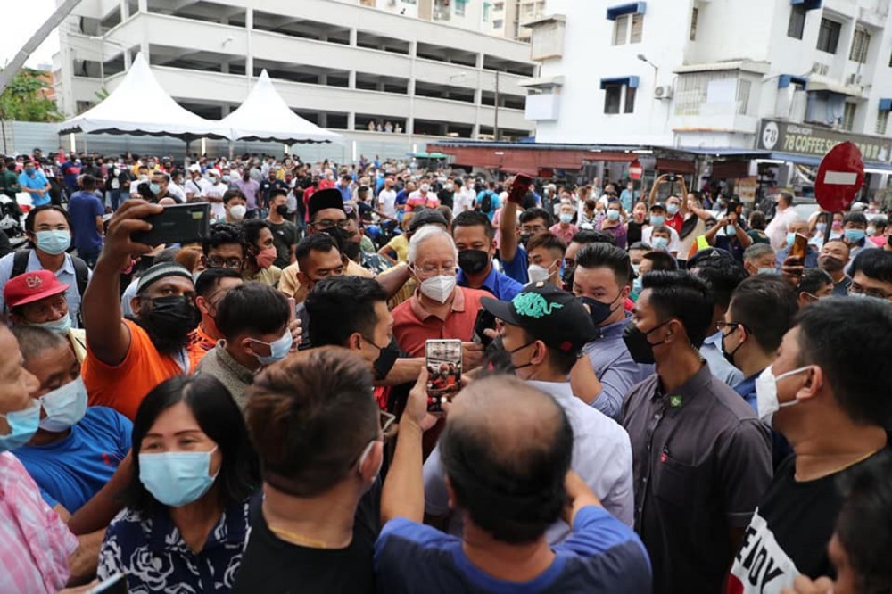 Datuk Seri Najib Razak is greeted by the public during his visit to the Jelutong night market, March 25, 2022. u00e2u20acu2022 Picture via Facebook/Najib Razak
