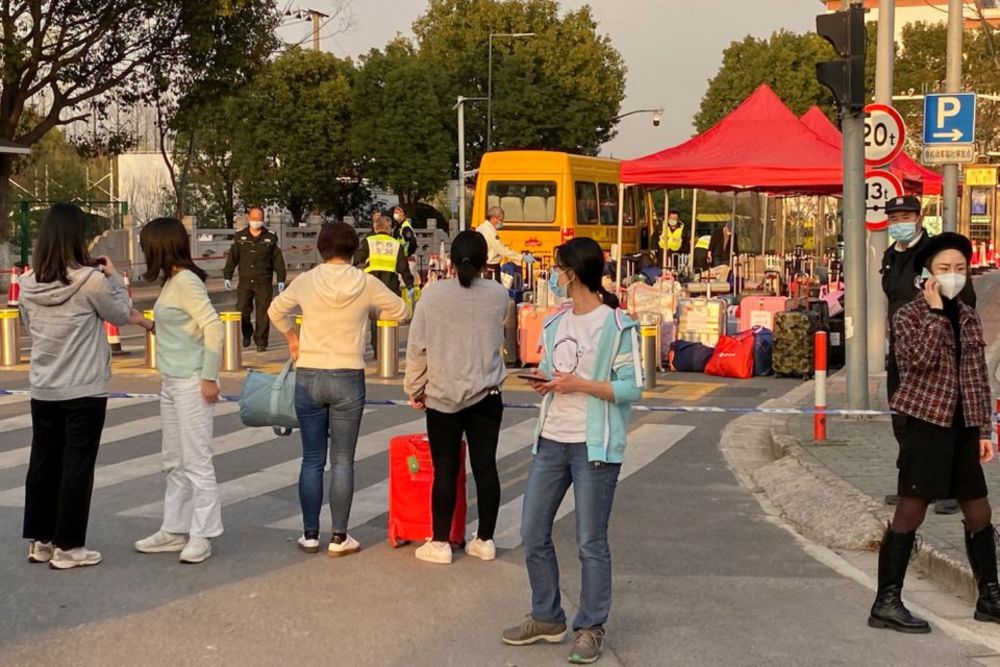 Parents stand behind a tape line as they deliver bags to children at a school under lockdown, following the coronavirus disease (Covid-19) outbreak in Shanghai, China, March 10, 2022. u00e2u20acu201d Reuters pic