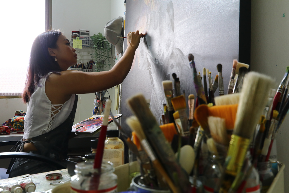 Mandy working on the final oil painting for Orikata Tales. —  Picture courtesy of Oh Chin Eng
