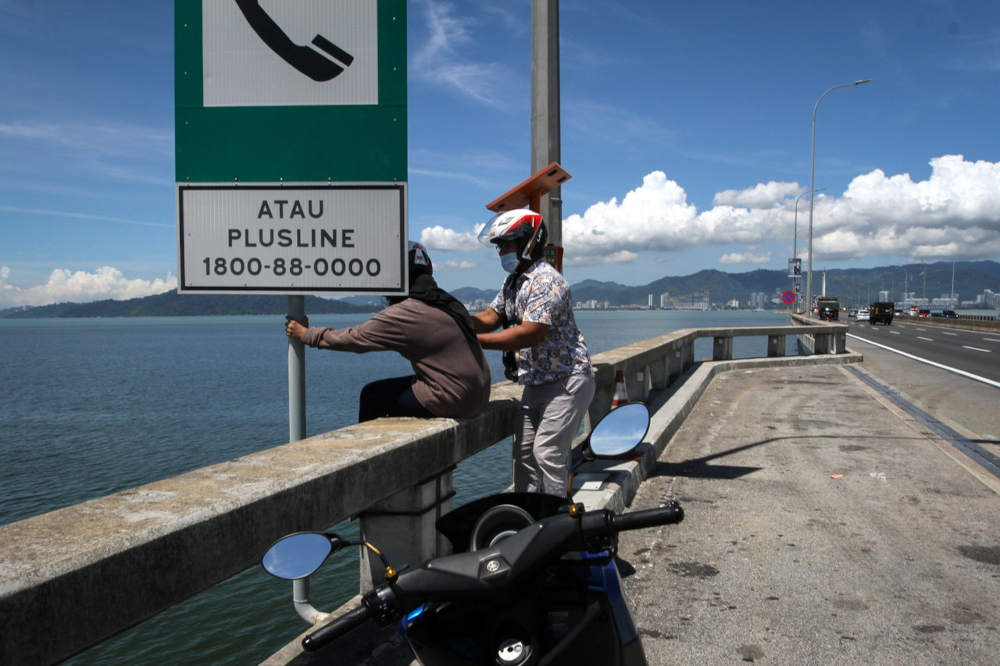 u00e2u20acu02dcThe Sunu00e2u20acu2122 photographer Masry Che Ani pulls a woman to safety at the Penang Bridge, March 9, 2022. u00e2u20acu201d Bernama pic 