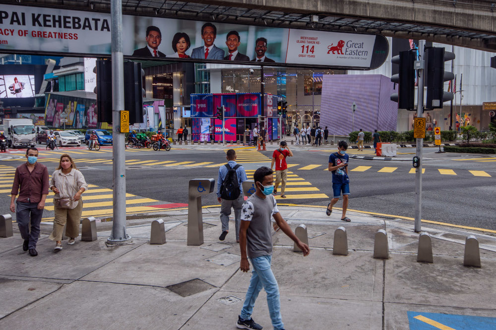 People are seen wearing protective masks as they walk along the Bukit Bintang shopping area in Kuala Lumpur, March 22, 2022. u00e2u20acu201d Picture by Shafwan Zaidon