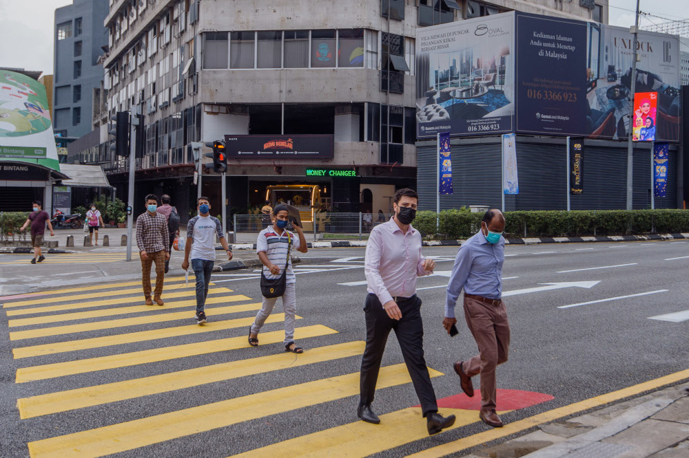 People are seen wearing protective masks as they walk along the Bukit Bintang shopping area in Kuala Lumpur, March 22, 2022. u00e2u20acu201d Picture by Shafwan Zaidon