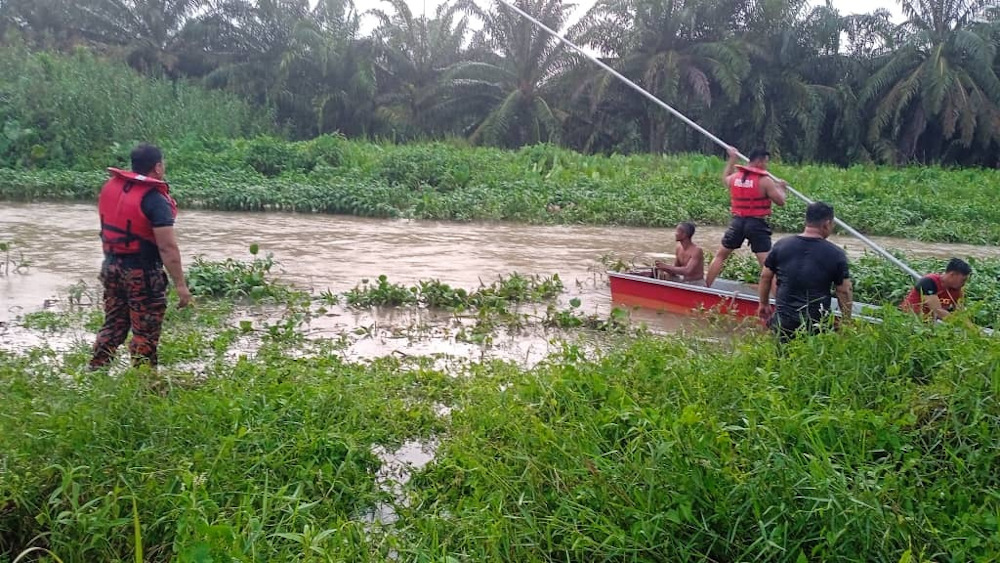 Fire and Rescue Department personnel conducting a search at a canal at Kilometer 32 Jalan Bota Kiri-Ulu Dedap near Kampung Gajah. u00e2u20acu201d Picture courtesy of Bomba