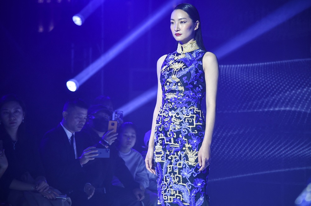 A model wearing traditional Chinese dress u00e2u20acu02dcqipaou00e2u20acu2122 rehearsing for a Shanghai fashion show. u00e2u20acu2022 AFP pic