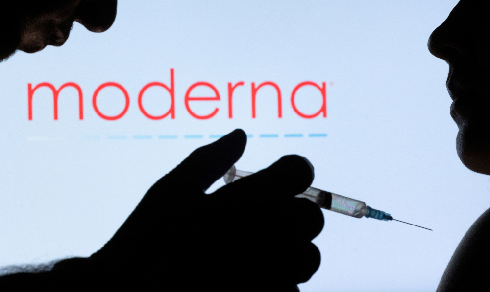 People pose with syringe with needle in front of displayed Moderna logo in this illustration taken, December 11, 2021. u00e2u20acu201d Reuters pic