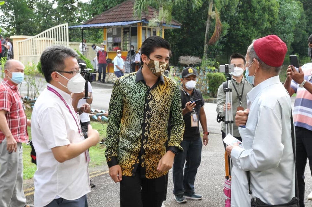 DAP's Perling candidate Liew Chin Tong (left) and Muda president Syed Saddiq Syed Abdul Rahman (centre) greet voters at the SK Taman Sutera polling centre in Johor Baru March 12, 2022 u00e2u20acu201d Picture by Ben Tan