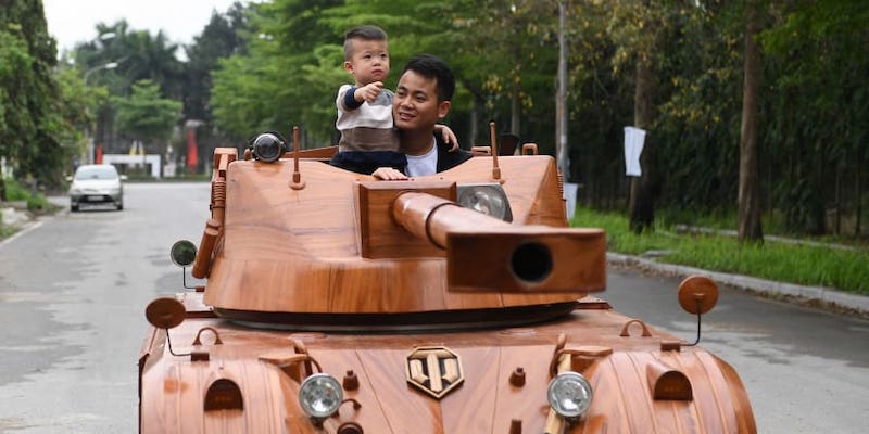 Truong Van Dao and his son ride in a wooden tank made from the conversion of an old minibus in a residential area in Bac Ninh province. u00e2u20acu201d AFP pic