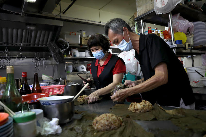 Susan Kwa, 58, head waitress, and Ngio Swer Tee, 63, chef, both working in the kitchen of Lai Wah Restaurant. — TODAY pic