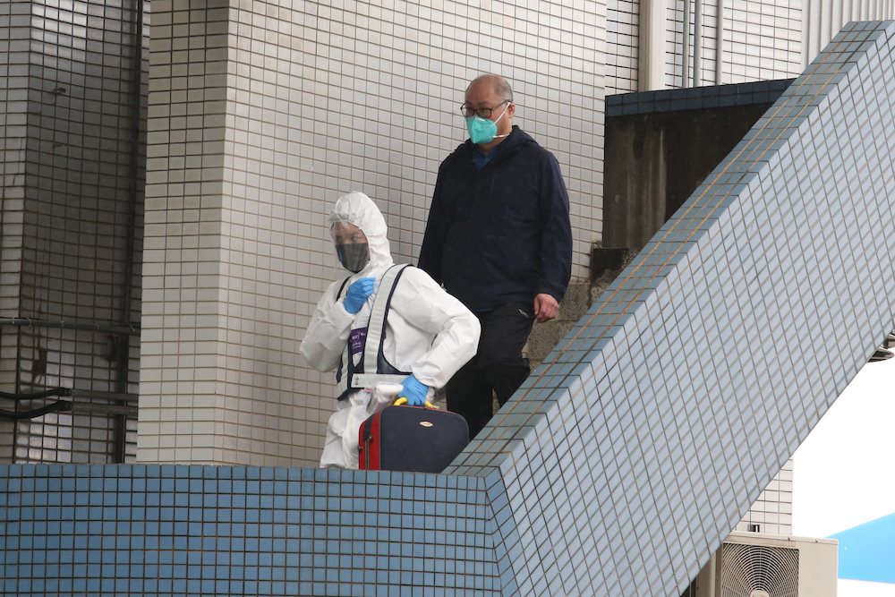 Taiwanese Lee Ming-che is escorted by epidemic prevention personnel after arriving at Taoyuan Airport in Taoyuan April 15, 2022. u00e2u20acu201d AFP pic