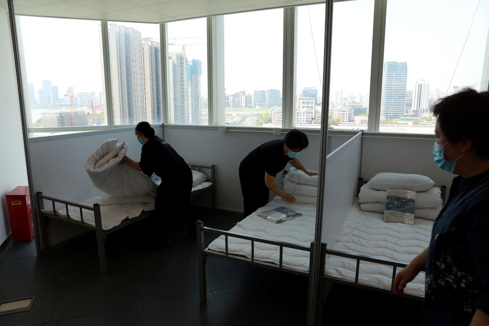 Workers make beds at a 17-storey office building to convert it into a makeshift hospital for Covid-19, in Shanghai, China April 12, 2022. u00e2u20acu201d China Daily via Reuters