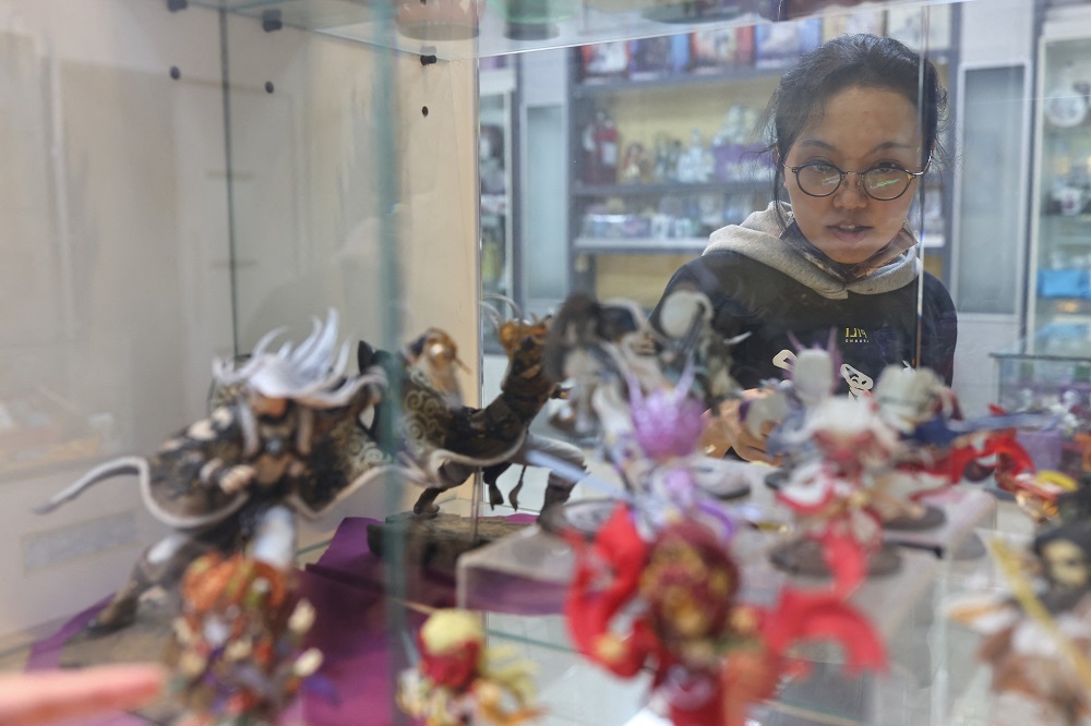 Seika Huang, brand director of Pili International Multimedia, looks at the models of various Pili puppet characters on display at their headquarters in Yunlin, Taiwan February 18, 2022. u00e2u20acu201d Reuters pic
